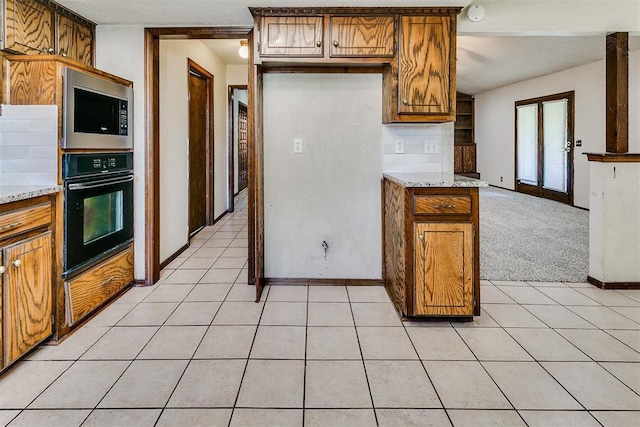 1405 Creston Way, Edmond, OK 73012 - kitchen featuring oven, stainless steel microwave, brown cabinets, light tile patterned floors, and light carpet