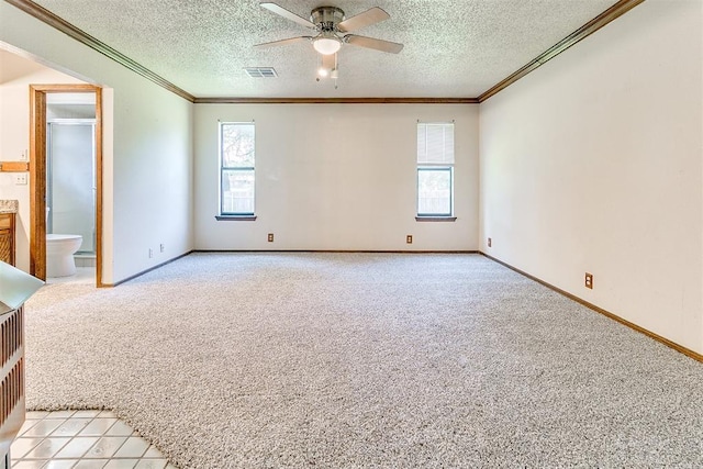 1405 Creston Way, Edmond, OK 73012 - unfurnished bedroom with multiple windows, light colored carpet, a textured ceiling, ornamental molding, and ensuite bath