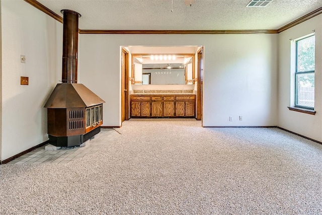 1405 Creston Way, Edmond, OK 73012 - unfurnished living room featuring ornamental molding, light colored carpet, a wood stove, and a textured ceiling