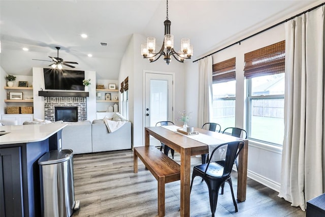 16336 Coldfire Rd, Oklahoma City, OK 73170 - dining space with a chandelier, wood finished floors, a ceiling fan, a fireplace, and vaulted ceiling