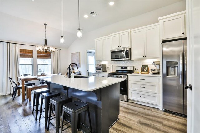 16336 Coldfire Rd, Oklahoma City, OK 73170 - kitchen with stainless steel appliances, a kitchen island with sink, light countertops, a chandelier, and tasteful backsplash
