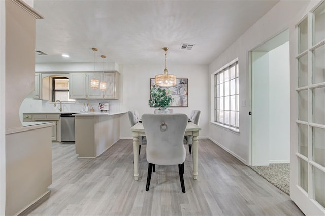 2617 NW 58th St, Oklahoma City, OK 73112 - dining space featuring light wood-style flooring and a chandelier