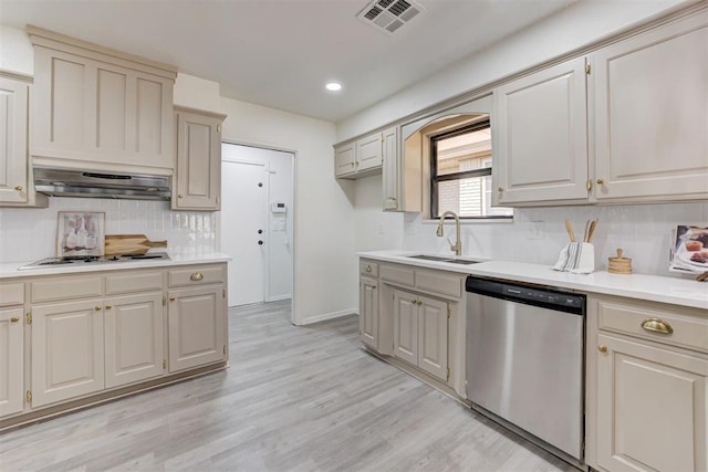 2617 NW 58th St, Oklahoma City, OK 73112 - kitchen with stainless steel dishwasher, extractor fan, white stovetop, tasteful backsplash, and light countertops