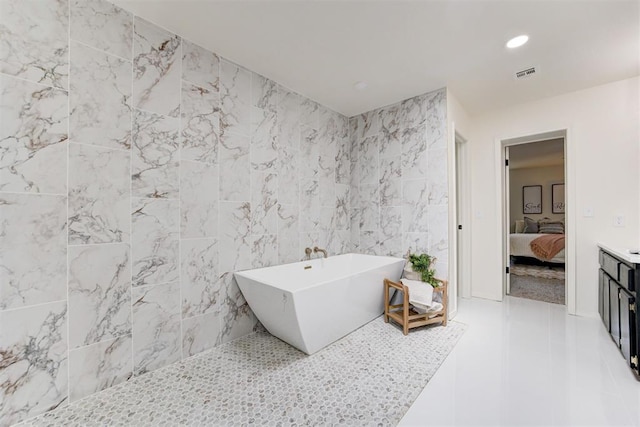 2617 NW 58th St, Oklahoma City, OK 73112 - ensuite bathroom featuring a freestanding bath, tile patterned flooring, recessed lighting, and tile walls