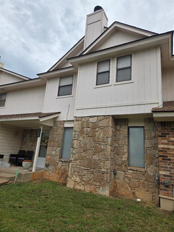 10623 White Oak Canyon Rd, Oklahoma City, OK 73162 - view of home's exterior featuring stone siding, a chimney, and a lawn
