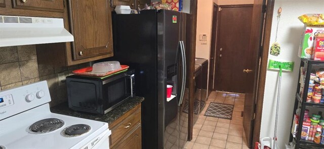 10623 White Oak Canyon Rd, Oklahoma City, OK 73162 - kitchen with white electric range oven, under cabinet range hood, black microwave, stainless steel fridge with ice dispenser, and light tile patterned floors