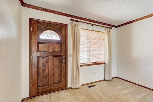 302 Tanglewood Dr, Yukon, OK 73099 - foyer with a textured ceiling, plenty of natural light, light colored carpet, and ornamental molding