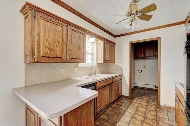 302 Tanglewood Dr, Yukon, OK 73099 - kitchen featuring tasteful backsplash, a peninsula, light countertops, brown cabinets, and a textured ceiling