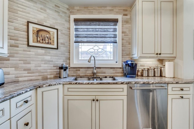 707 NE 18th St, Oklahoma City, OK 73105 - kitchen with stainless steel dishwasher, backsplash, light stone counters, and cream cabinetry