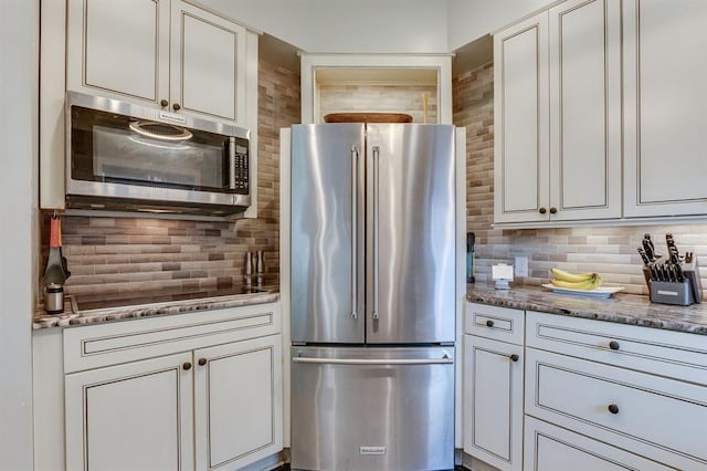 707 NE 18th St, Oklahoma City, OK 73105 - kitchen featuring appliances with stainless steel finishes, tasteful backsplash, white cabinetry, and stone countertops