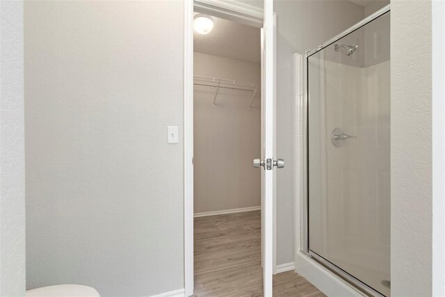 1908 E View Dr, Norman, OK 73071 - bathroom with a stall shower, wood finished floors, and a walk in closet