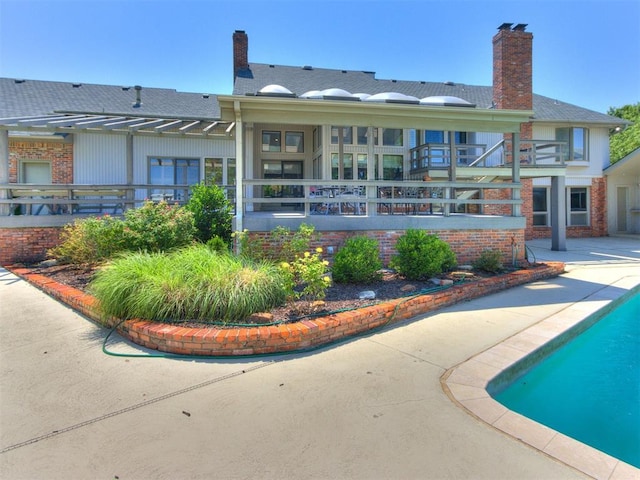 9 Country Club Rd, Shawnee, OK 74801 - rear view of property featuring brick siding, a chimney, an outdoor pool, and a patio