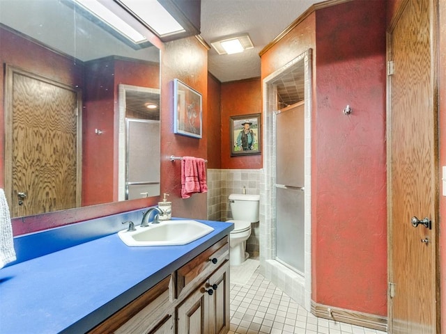 9 Country Club Rd, Shawnee, OK 74801 - full bathroom with tile patterned floors, toilet, vanity, a stall shower, and tile walls