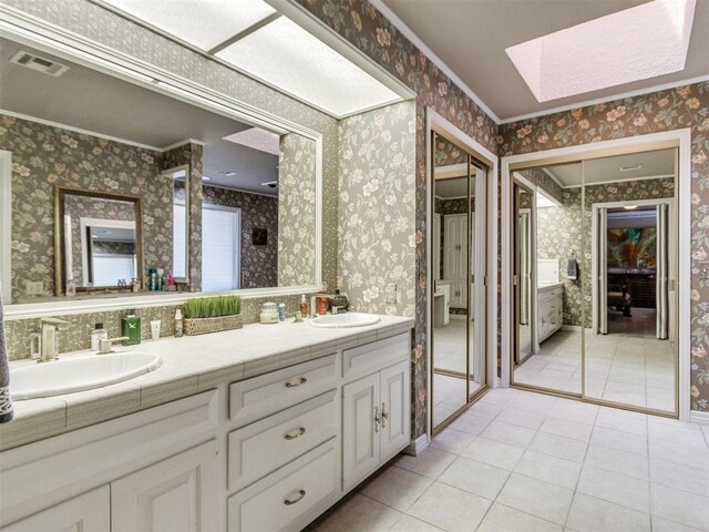 9 Country Club Rd, Shawnee, OK 74801 - full bath with a skylight, double vanity, tile patterned flooring, wallpapered walls, and crown molding