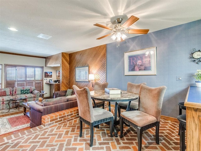 9 Country Club Rd, Shawnee, OK 74801 - dining space with brick floors, a ceiling fan, and wooden walls