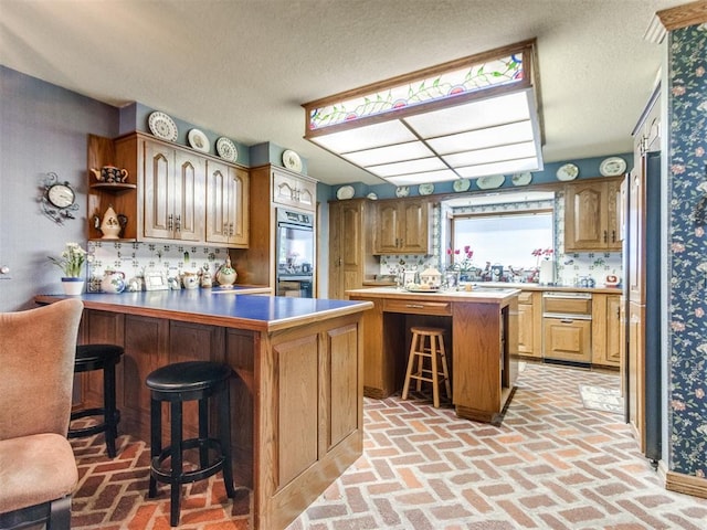 9 Country Club Rd, Shawnee, OK 74801 - kitchen with a peninsula, brick floors, a breakfast bar, a textured ceiling, and a warming drawer