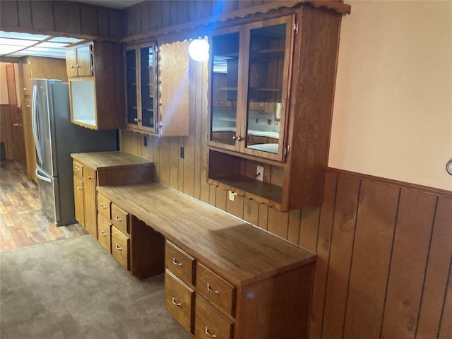 103 N Armor Ave, Canton, OK 73724 - kitchen with wooden walls, brown cabinets, butcher block countertops, glass insert cabinets, and freestanding refrigerator