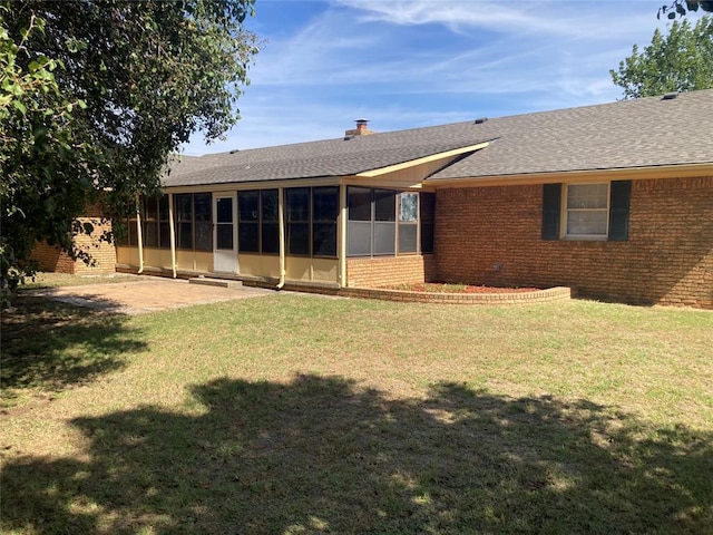 103 N Armor Ave, Canton, OK 73724 - rear view of property featuring brick siding, a sunroom, a shingled roof, and a lawn