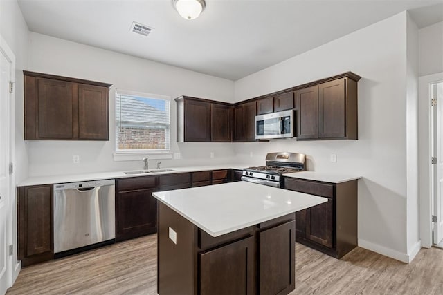14308 Peach Tree Dr, Yukon, OK 73099 - kitchen with appliances with stainless steel finishes, light wood-style floors, dark brown cabinetry, and light countertops