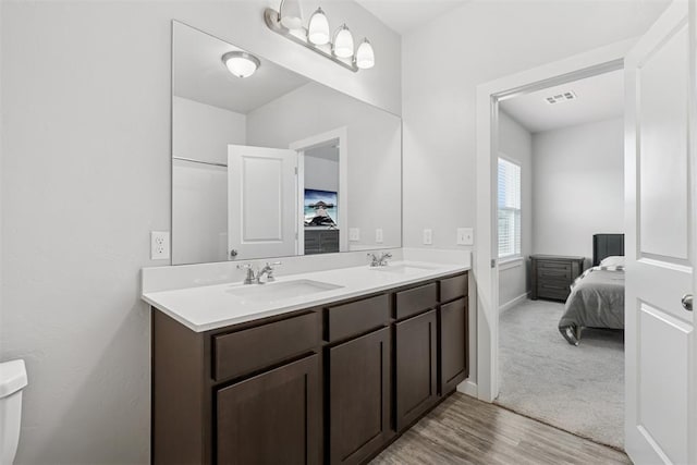 14308 Peach Tree Dr, Yukon, OK 73099 - ensuite bathroom with double vanity and wood finished floors