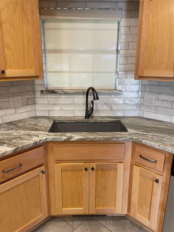 3017 Kelsey Dr, Edmond, OK 73013 - kitchen with a sink, backsplash, stone countertops, and light tile patterned flooring