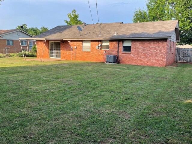 3017 Kelsey Dr, Edmond, OK 73013 - back of house with brick siding, central AC, and roof with shingles