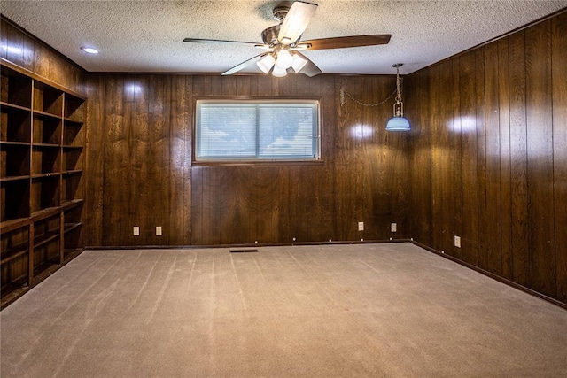 801 N Hunt St, Hydro, OK 73048 - carpeted empty room with a textured ceiling, ceiling fan, and wooden walls