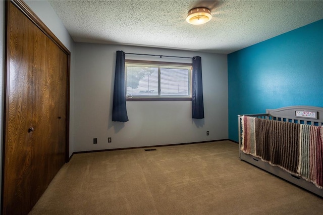 801 N Hunt St, Hydro, OK 73048 - unfurnished bedroom with carpet floors, a closet, and a textured ceiling