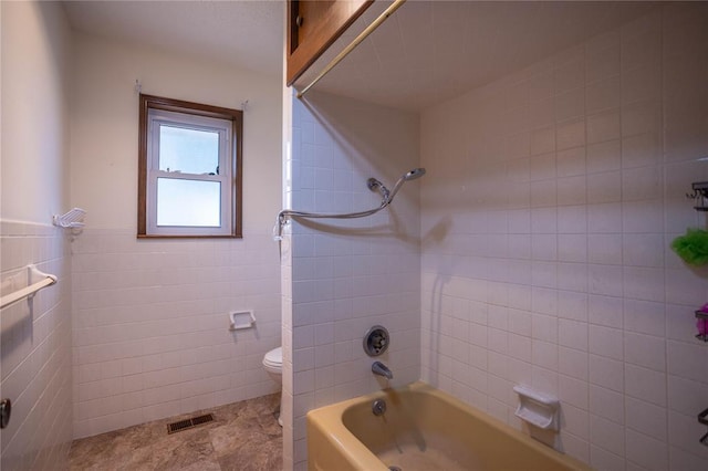 801 N Hunt St, Hydro, OK 73048 - bathroom with tile walls, bathing tub / shower combination, a wainscoted wall, and tile patterned flooring