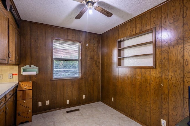 801 N Hunt St, Hydro, OK 73048 - spare room featuring a ceiling fan, wooden walls, and a textured ceiling