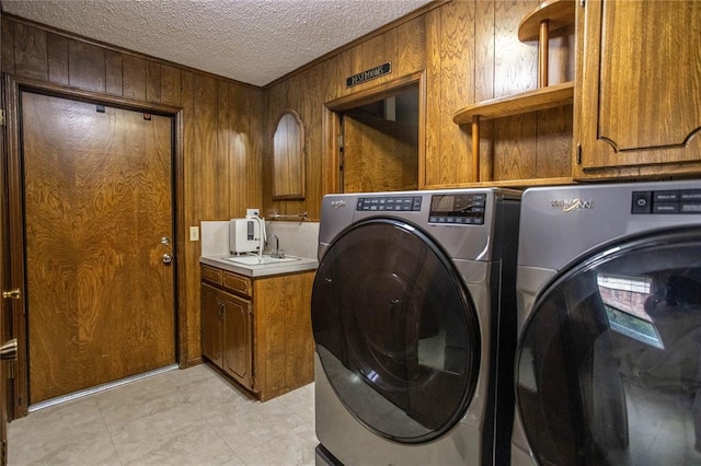 801 N Hunt St, Hydro, OK 73048 - laundry room with washing machine and clothes dryer, cabinet space, wooden walls, and a textured ceiling