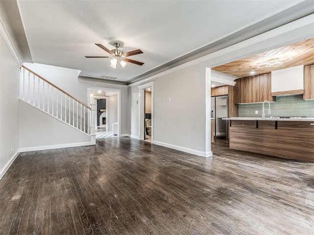 3157 NW 25th St, Oklahoma City, OK 73107 - unfurnished living room featuring ceiling fan, dark wood-style floors, stairway, and crown molding