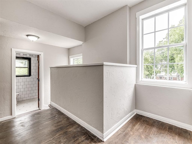 3157 NW 25th St, Oklahoma City, OK 73107 - corridor with a textured wall, wood finished floors, and healthy amount of natural light