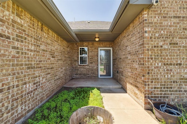868 Phils Way, Piedmont, OK 73078 - entrance to property with brick siding, roof with shingles, a patio area, and a surveillance system
