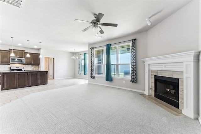 868 Phils Way, Piedmont, OK 73078 - unfurnished living room with a fireplace, a ceiling fan, recessed lighting, light colored carpet, and a chandelier
