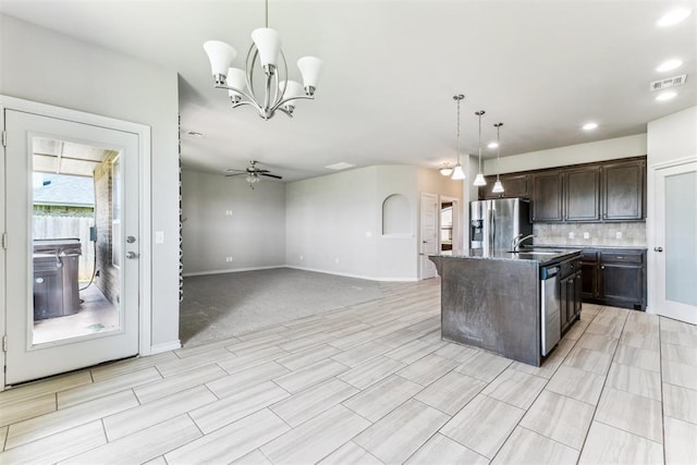 868 Phils Way, Piedmont, OK 73078 - kitchen featuring stainless steel appliances, dark brown cabinets, tasteful backsplash, ceiling fan, and an island with sink