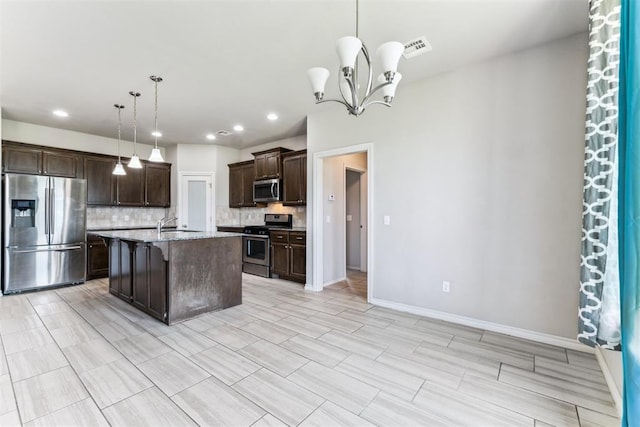 868 Phils Way, Piedmont, OK 73078 - kitchen with appliances with stainless steel finishes, backsplash, dark brown cabinets, a chandelier, and a breakfast bar