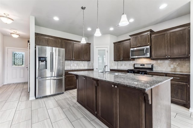 868 Phils Way, Piedmont, OK 73078 - kitchen featuring stainless steel appliances, dark brown cabinetry, backsplash, dark stone counters, and pendant lighting
