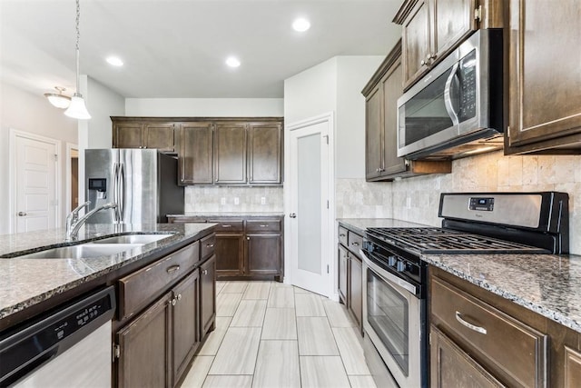 868 Phils Way, Piedmont, OK 73078 - kitchen featuring stainless steel appliances, dark stone countertops, dark brown cabinets, decorative backsplash, and recessed lighting