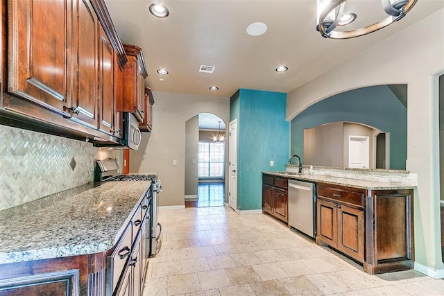 3393 Creek View Ct, Newcastle, OK 73065 - kitchen with appliances with stainless steel finishes, baseboards, arched walkways, decorative backsplash, and recessed lighting