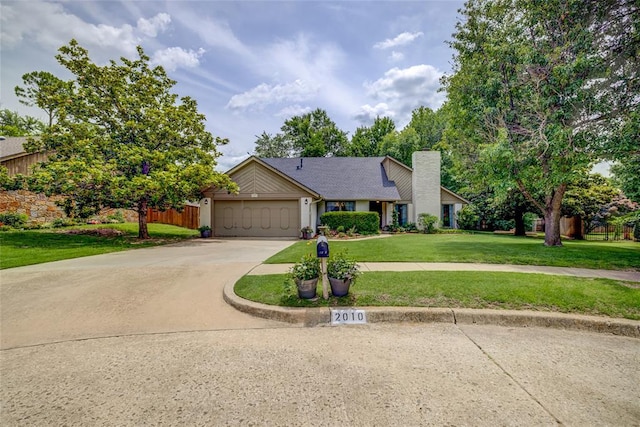 2010 Trailview Ct, Norman, OK 73072 - view of front facade with driveway, a garage, and a chimney
