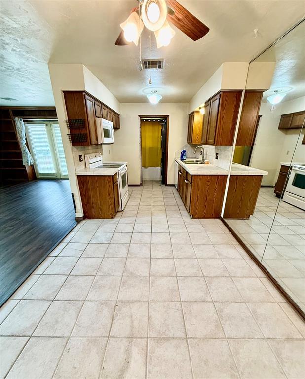 4400 Hemingway Dr Unit 263, Oklahoma City, OK 73118 - kitchen with white appliances, a sink, light tile patterned floors, and light countertops