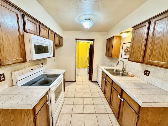 4400 Hemingway Dr Unit 263, Oklahoma City, OK 73118 - kitchen with white appliances, a sink, backsplash, brown cabinets, and a textured ceiling
