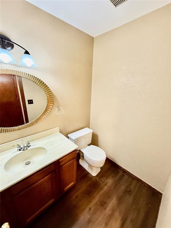 4400 Hemingway Dr Unit 263, Oklahoma City, OK 73118 - half bath with wood finished floors, vanity, and toilet