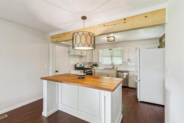 3029 NW 65th St, Oklahoma City, OK 73116 - kitchen featuring wooden counters, stainless steel appliances, tasteful backsplash, dark wood-style floors, and pendant lighting