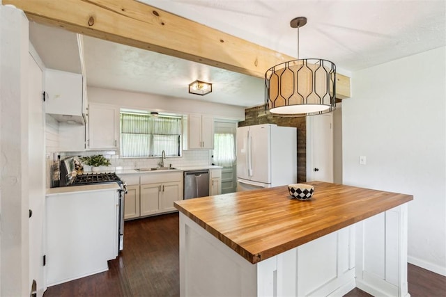 3029 NW 65th St, Oklahoma City, OK 73116 - kitchen with appliances with stainless steel finishes, butcher block countertops, dark wood-style flooring, white cabinetry, and backsplash