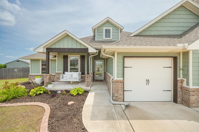 10800 NW 5th St, Yukon, OK 73099 - craftsman-style home with a porch, an attached garage, driveway, a shingled roof, and brick siding