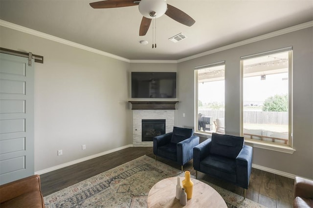 10800 NW 5th St, Yukon, OK 73099 - living area featuring a fireplace, wood finished floors, crown molding, ceiling fan, and a barn door
