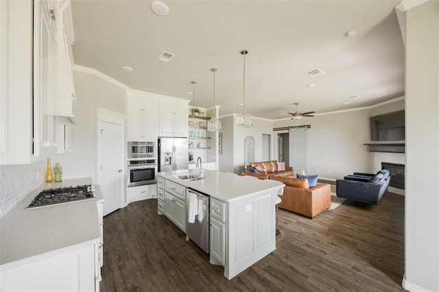 10800 NW 5th St, Yukon, OK 73099 - kitchen featuring stainless steel appliances, white cabinetry, crown molding, a ceiling fan, and a glass covered fireplace