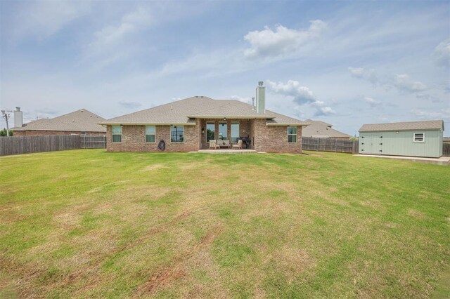 10800 NW 5th St, Yukon, OK 73099 - back of house with a fenced backyard, a chimney, a patio area, and brick siding
